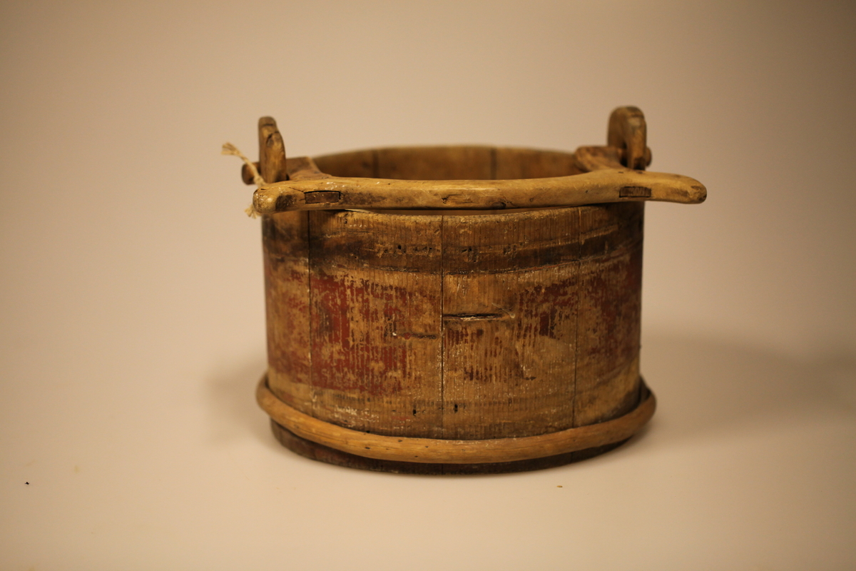 Lagget med 2 gjorder, men den øverste er borte. Bevegelig tverrhank med tretapper, to ører og innfelt bunn. Formen er rund, sylinderformet, uten lokk eller ben. Har vært påmalt rød farge. Brukt til melk.