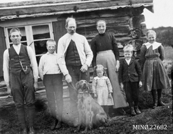 Seterbilde, personer oppstilt foran seterstue