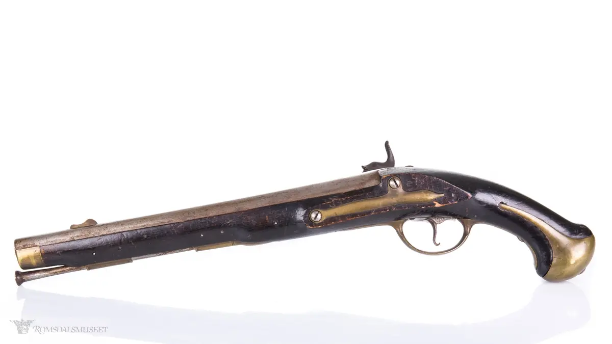 Flintlåspistol med glattboret løp, uten baksikte og med åpent korn. Skjefte av bøk med messingbeslag i enden og ved munningen. To røkner med ladestokk.