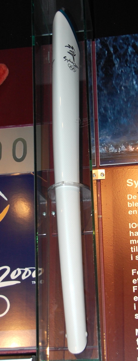 Emblemet for Sydney 2000 øverst på fakkelen, deretter teksten Sydney 2000 og så de olympiske ringene.Fakkelen er inspirert av Sydney Opera House, formen på  boomerangen og det blå for Stillehavet. Designet av Blu Sky Design/GA & Harrington. Brensel var propan og butan.