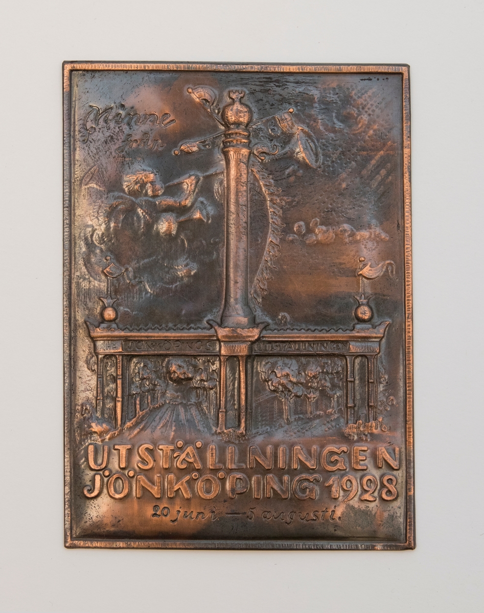 Plakett av rost-brun-färgad metall med reliefmönster föreställande entréportalen till Jönköpingsutställingen 1928. Portalen har två öppningar mellan tre pelarpar. Centralt på portalen reser sig en hög pelare.