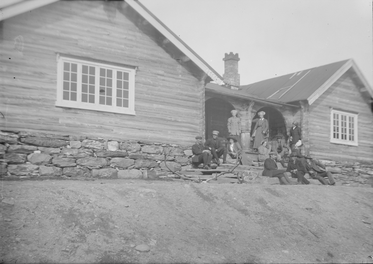 Sjodalen, Bessheim med en gruppe menn og kvinner på trappen, to gevir ligger på bakken