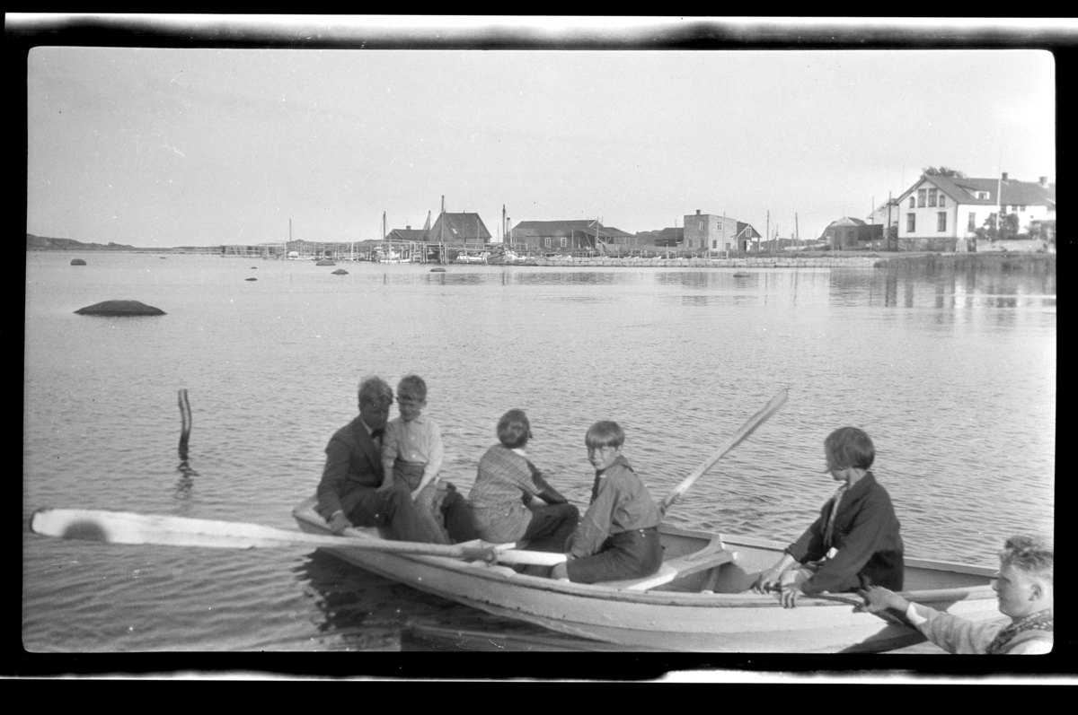 Fire barn og en mann i robåt utenfor Stavern(?). Einar Aubert Hansen ved årene. Fotografert 1928.