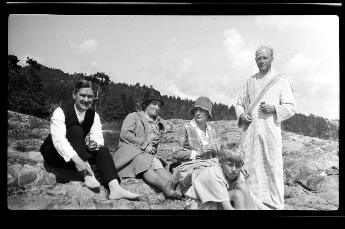 Ekteparet Albert og Claire Weber, Hilda Sundt, Rolf Sundt jr., en ukjent dame og Rolf Sundt sr. sitter på svaberg på Høvikvollen, Røyken. Fotografert 1930.