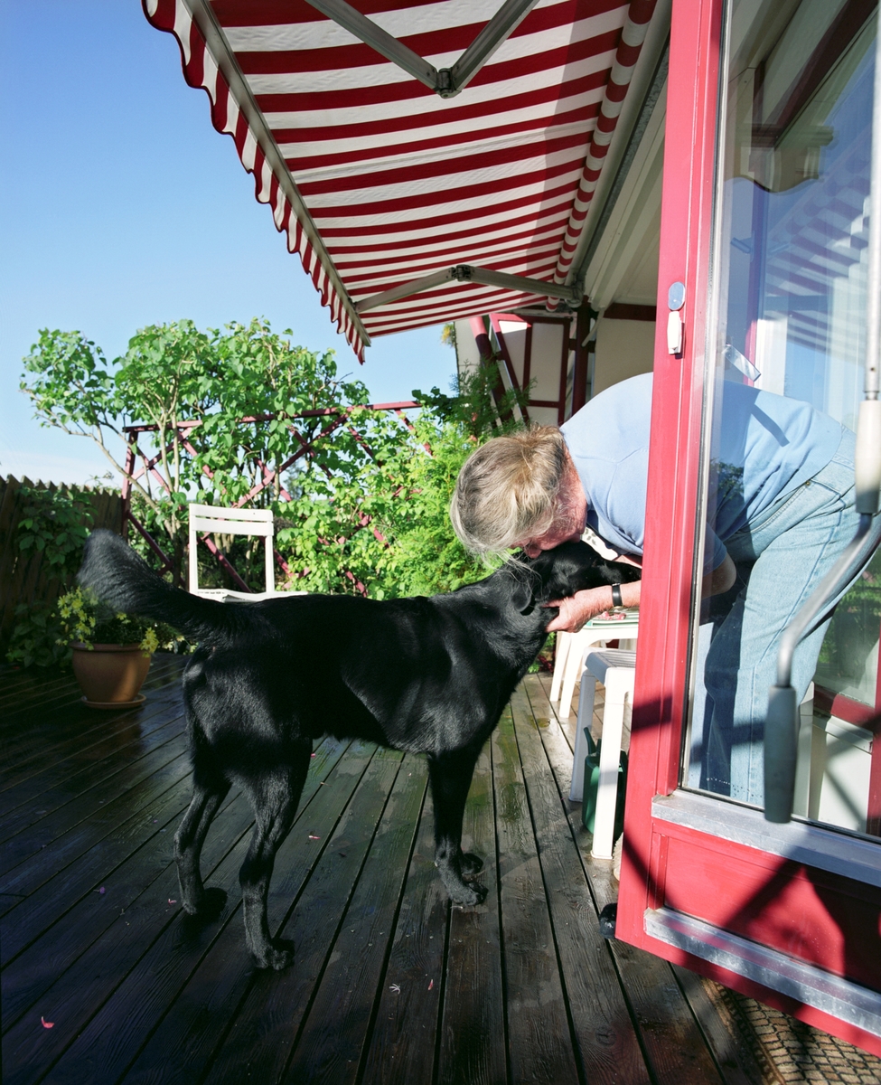 Hunden Chico på terrassen koser med sin eier.