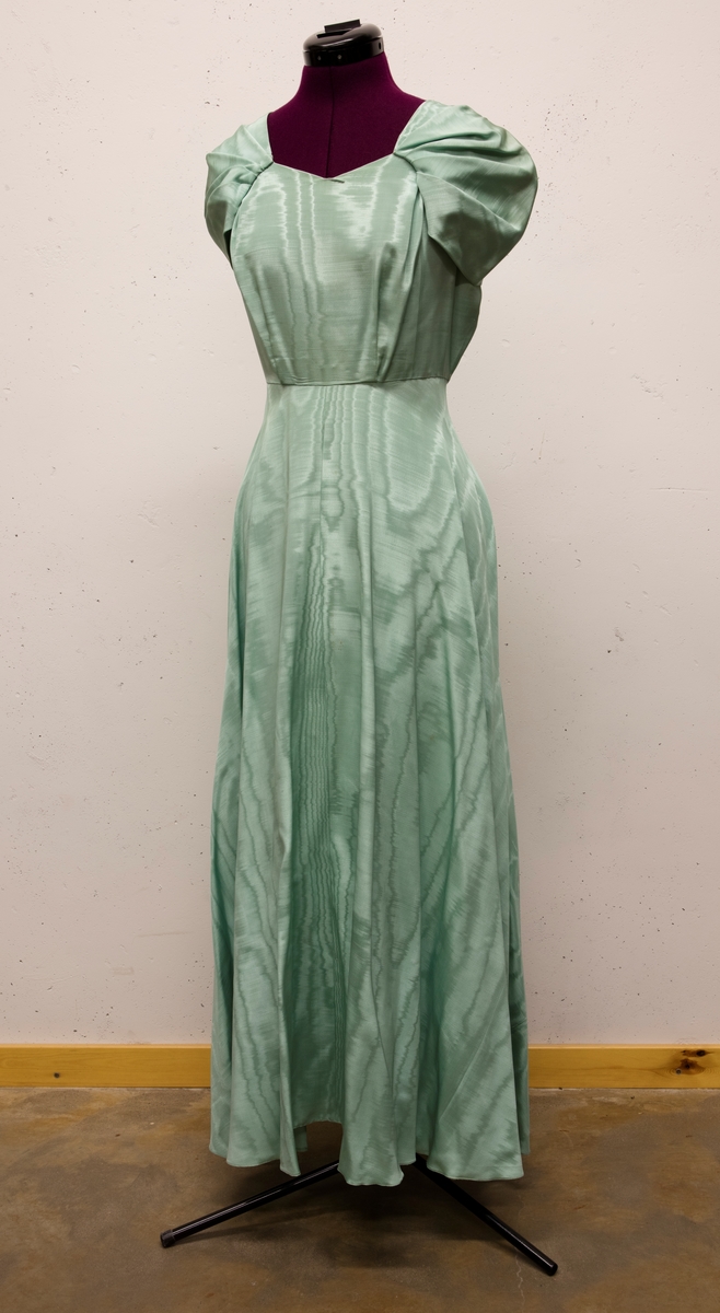 Lång klänning sydd 1947 till Berta Lundell för ett bröllop.
Tyget är så kallad moiresiden. Draperingar över axlarna.