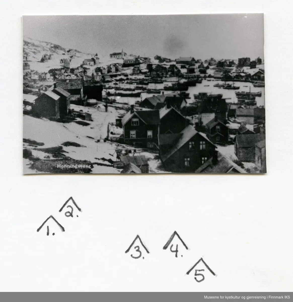 Postkortmotiv. Bebyggelsen i Honningsvåg. Mange båter i Indre havn. Kirka i bakgrunnen. 1930-årene.