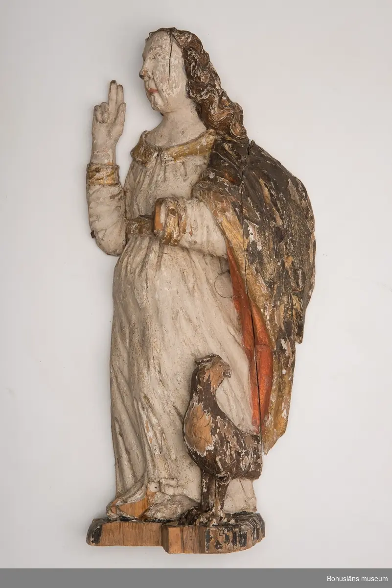 Skulptur, apostelbild från 1600-talet som tillhör altartavla UM000393.
Krederat trä med mager oljefärg och oljeförgyllning. Förgyllningen uppvisar båda bladguld, slagmetall och/eller silver.

Ur handskrivna katalogen 1957-1958:
Apostelbild, Lane Ryr 
H. 40 cm; Kristus, höger hand höjd t. välsignande åtbörd, vänster bär ett klot; färgen delvis flagn; sprickor.
Krederat trä med mager oljefärg och oljeförgyllning. Förgyllningen uppvisar båda bladguld, slagmetall och/eller silver.
Lappkatalog: 13

Se foto på föremålet i Uddevalla museums kyrkliga utställning 1920, UMFA54467:0422.

Ytterligare en kyrklig skulptur är märkt med inventarienummer UM394, aposteln Johannes med välsignelsegest och en örn, manteln är har rödmålad insida. Denna skulptur återfinns emellertid inte på äldre bilder av altartavla UM000393, den äldsta fotot UMFA916 samt ett yngre fotografi, UMFA917 som är taget i kyrkliga utställningen av Maria Lundbäck, och alltså inte kan vara senare än år 1927.

Ur Nationalencyklopedin, NE.se:  Apostel
I konsten framställs apostlarna alltid barfota samt klädda i tunika och mantel. De bär oftast en bok samt sitt individuella attribut, i allmänhet respektive martyrredskap (Petrus bär dock himmelrikets nycklar).