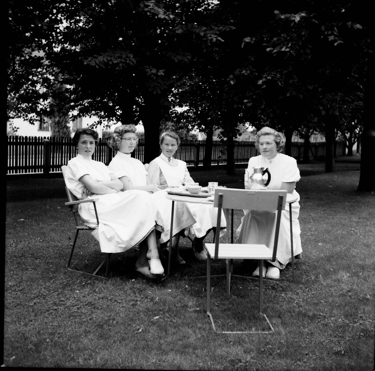 Fyra sjuksköterskor har kafferast i trädgården.