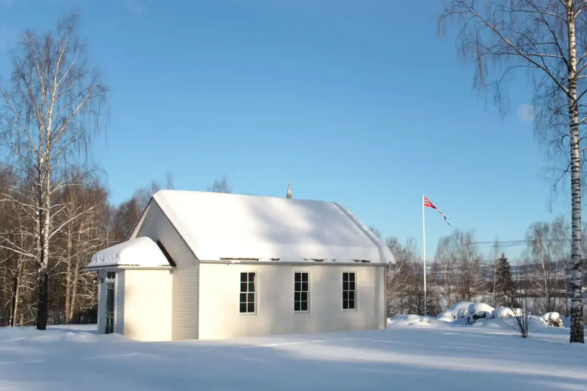 Skolestua dekket i snø ute på friluftsmuseet