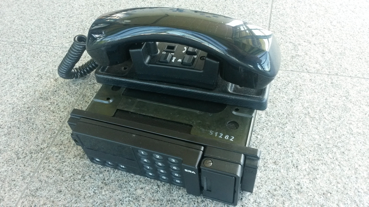Panelmonterad mobiltelefon NMT 450, med extra sats för telefonering från baksätet.