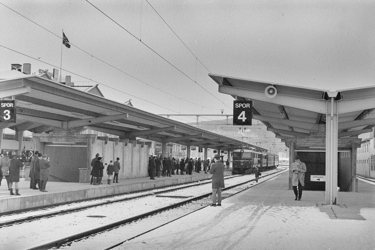 Mange fremmøtte på plattformen på Trondheim stasjon i forbindelse med åpningen av Dovrebanen for elektrisk drift. Åpningstoget kjører inn på stasjonen.