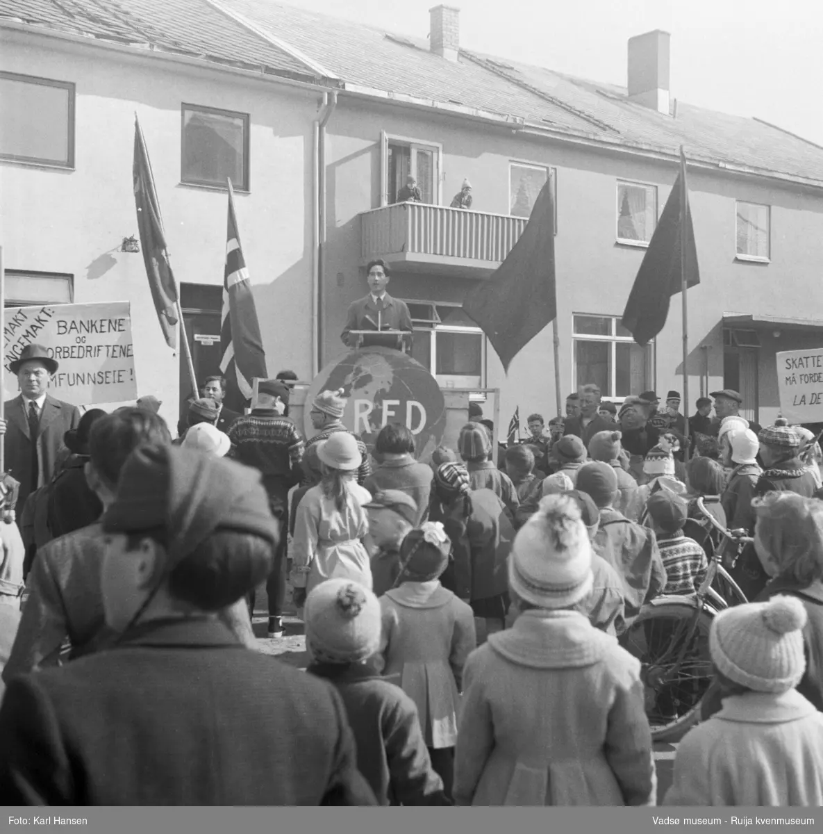 Vadsø 1.mai 1960. Samling og tale på Torget. Bygningen bak taleren er Henriksens bakeri.