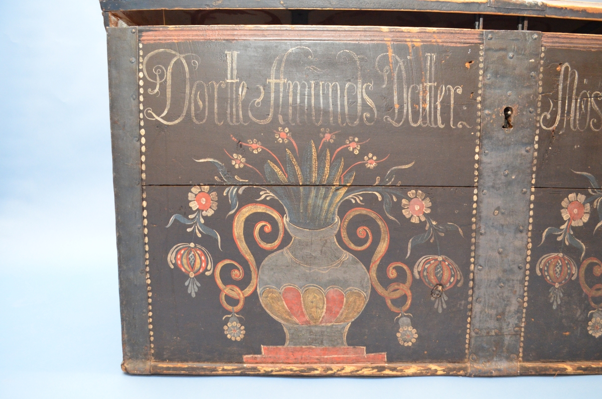Rosemåla kiste med blomar, rankar, urner, prikkar og skrift. Påført skrift seier: Dortte Amunds Datter Mosagger Anno 1822.