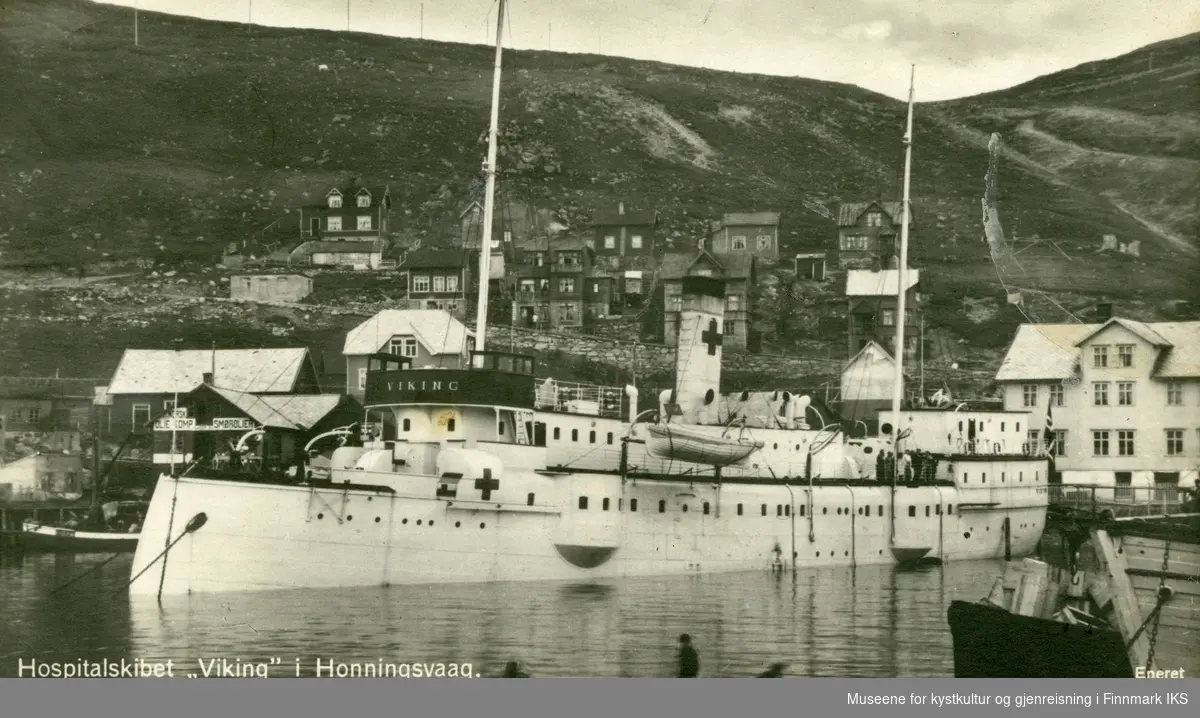 Postkort. Hospitalskipet 'Viking' i Honningsvåg. Blikk mot Elvedalen. Lengst til høyre Toklegården. Kortet er stemplet 'Breivikbotn 7XI26', og ble sendt til Gaashopen (antatt Gåshopen/Sørøya). 1924-1926.