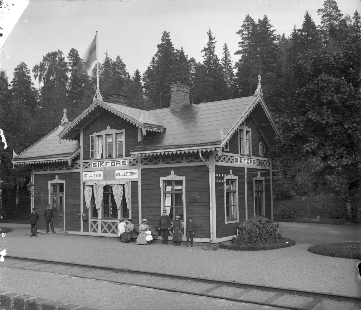 Stationens personal med familjer poserar framför stationshuset.