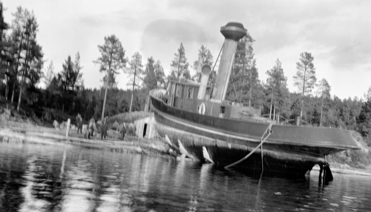 D/S Storsjø landsettes 7. mai 1915.  Fotografiet er tatt fra en robåt på Storsjøen.  Det viser båten med akterenden i innsjøen mens båten fortsatt støttes opp av bukker på slippen.  Fartøyet er bygd av jern, og platene i skroget er klilnket sammen.  På dekk ses ei lita kasse med dør, som antakelig er nedgangen til maskinrommet.  Foran denne ses ei høy skorsteinspipe med gnisthatt.  Foran denne igjen ses styrhuset.  På land, til venstre for båten står en del menn på slippen, som er en steinforet tømmerkonstruksjon.  Ved siden av slippen ses gavlen på ei bu som er delvis nedgravd i strandbakken.  Bakom dette vokser det barskog. 

Direksjonen i Glomma Fellesfløtingsforening vedtok å investere i en dampbåt som skulle trekke tømmer i bommer over denne sjøen i 1911.  Båten var ferdig og ble satt i drift allerede påfølgende sesong.  Dette fartøyet ble brukt til å trekke tømmerbommer over Storsjøen inntil tømmerfløtinga i Glommavassdraget ble avviklet i midten av 1980-åra. 