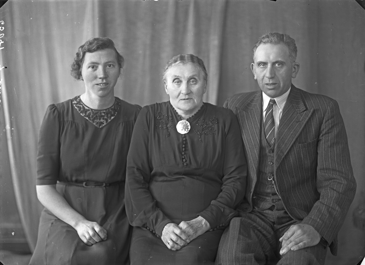 Gruppebilde. Familegruppe på tre. Ung kvinne, eldre kvinne og mann. Bestilt av Anna Lunde. Kirkegt. 178.