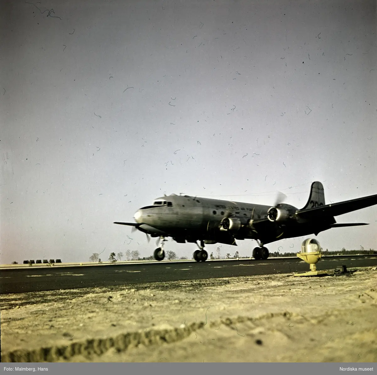 Berlinblockaden. Ett amerikanskt transportflygplan av typen Douglas C-54 Skymaster landar på ett flygfält.