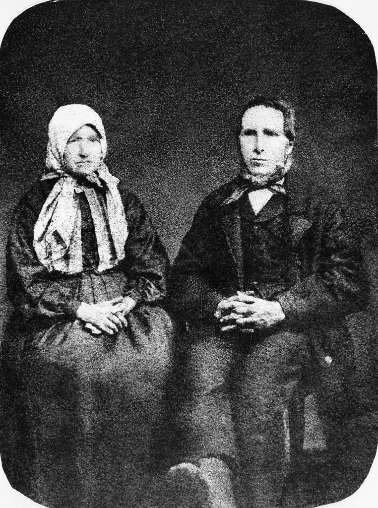 Laurense (Laurinda) Toresdtr. Kartevoll (1812 - 1885) og Ole Jonson Taksdal (1811 - 1882). 
Laurense har rosete hovudplagg med lange snippar som dekker brystet. Ole bruker vest og halstørkle.