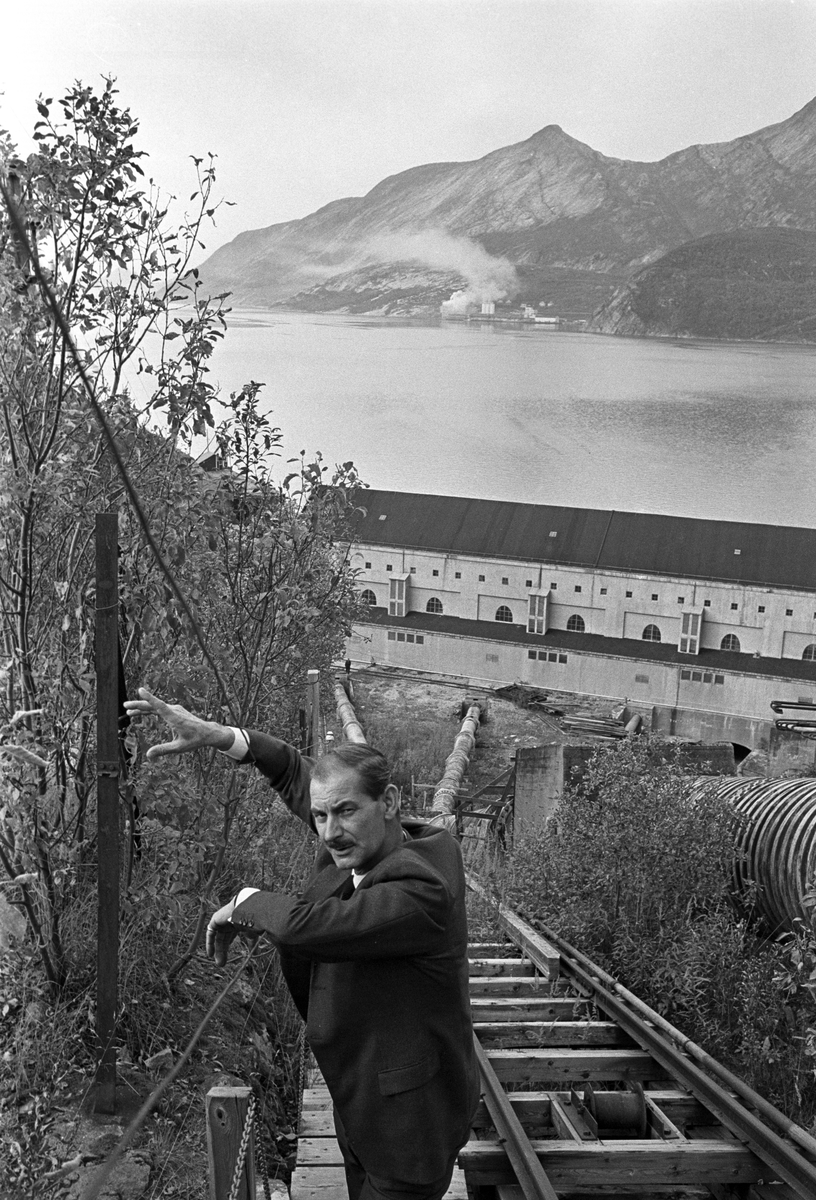 John Fairclough er tilbake i Glomfjord etter 23 år. Han var en av 12 kommandosoldater som overlevde Glomfjord-raidet i 1942. Her er Fairclough ved rørene til Vassdragsvesenets kraftstasjon i bakgrunnen.