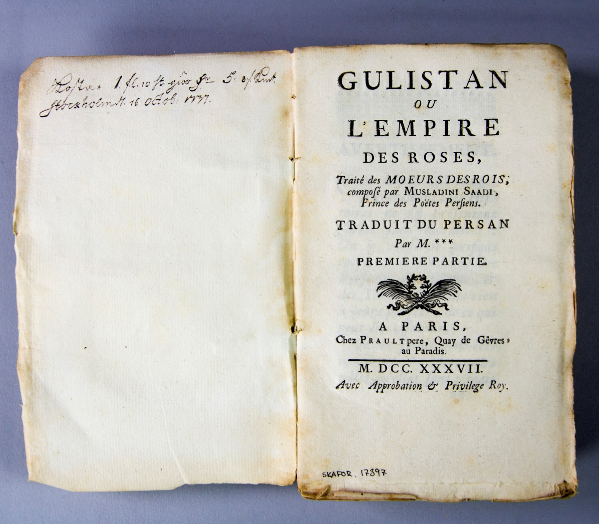 Bok, pappband, "Gulistan ou l'empire des roses", skriven av Musladini Saadi, tryckt 1737 i Paris. Pärmar av marmorerat papper, blekt rygg med påklistrade etiketter, oläsliga. Oskuret snitt. Anteckning om inköp på pärmens insida.
