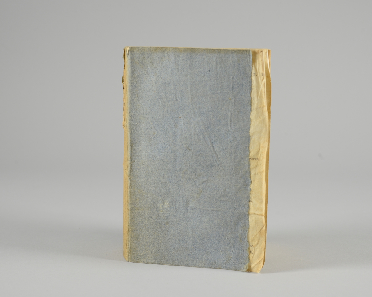Bok, pappband,"Oeuvres completes de Voltaire", del 29, tryckt 1785.
Pärmen klädd med gråblått papper, skurna snitt. På ryggen klistrad pappersetikett med tryckt text samt volymens nummer. Ryggen blekt.