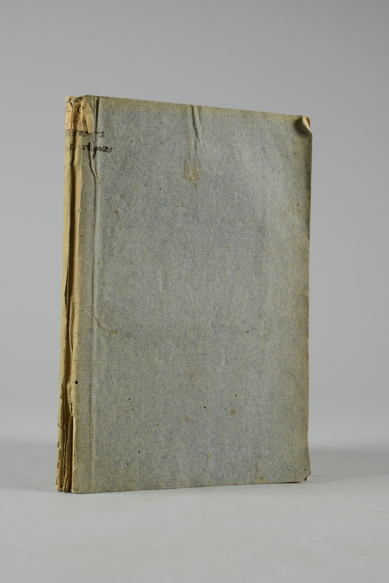 Bok, pappband, "Mémoires authentiques pour servir à l´histoire du comte de Cagliostro", tryckt 1785 i London. Pärmar av gråblått papper, på insidan klistrade sidor ur annan bok. På ryggen bokens titel samt etikett med samlingsnummer. Skuret snitt.