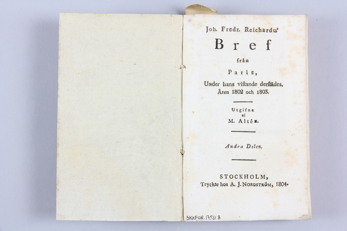 Bok, häftad "Joh. Fredr. Reichhardt's Bref från Paris, under hans vistande derstädes, åren 1802 och 1803", del 2, tryckt 1804 i Stockholm.
Pärm av marmorerat papper, skuret snitt. Etikett med samlingsnummer på ryggen.