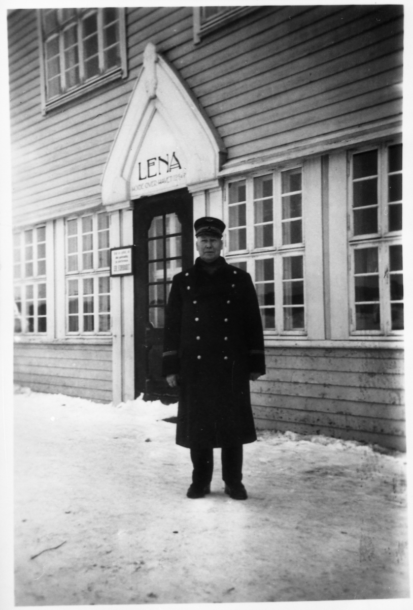 Avfotografert helfigurs portrett av en uidentifisert mann foran stasjonsbygningen på Lena. Mannen er iført en uniform som trolig er NSB's.