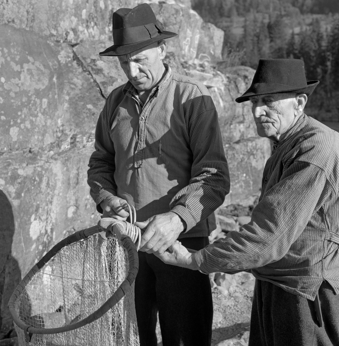 Lågåsildfiskerne Ole Haugen (1912-1982) og Arne O. Haugen (1883-1974, Oles far), fotografert ved bredden av Gudbrandsdalslågen, der de viste fram en stokkhåv hvor de nettopp hadde bundet «hugguet» på «rauna» (skaftet).  Rauna var lagd av langsomtvokst, seig tennargran.  På stokkehåver brukte rauna å være 6,5 til 8,5 meter lang.  Håvhugguet ble lagd av grankvister  med litt stammeved i endene.  Denne stammeveden som ble brukt som anlegg på enden av rauna.  Kvistene ble bøyt mot hverandre, slik at de dannet ei bøyle, som «påsan» kunne bindes på.  Sammenføyinga ble gjort ved hjelp av et par spikere og påsurret tau eller, som her, splittet bambus.  Påsan var et nett, bundet av lin.   Bak karene ser vi et flettet bæreredskap, en såkalt «snik», som ble brukt som beholder for fangsten.   Både far og sønn Haugen var kledd i vadmelsbukser og busserull, og de brukte svarte, vidbremmete hatter som hodeplagg.

Stokkehåven ble brukt fra en båt - ei «åfløy» - som var forankret i en stokk, som i sin tur var festet i stein i elveløpet.  Deler av fiskeribiologen Hartvig Huitfedt-Kaas' beskrivelse av håvene og stokkhåvfisket fra 1917 er gjengitt under fanen «Opplysninger».