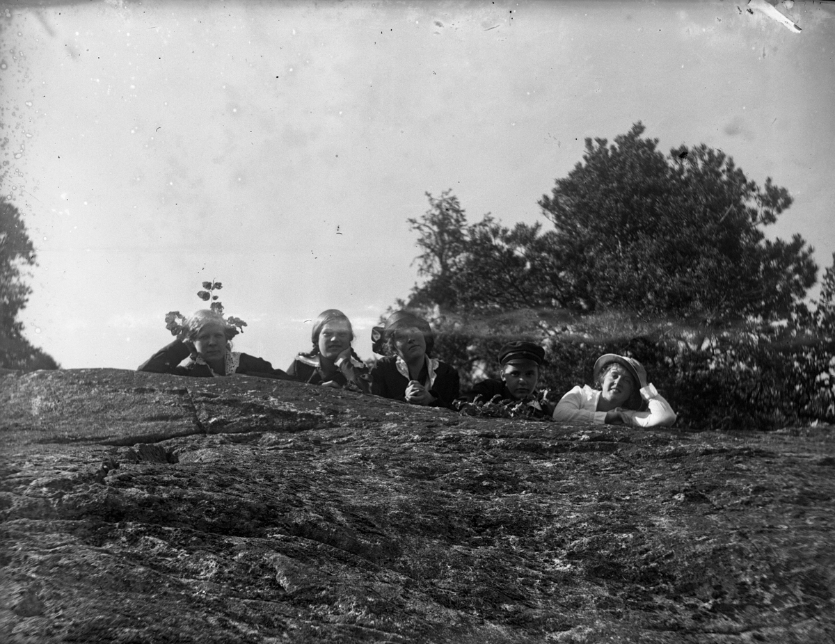 Fem flickor poserat på en sten i skogen. I fotografens egna katalog står antecknat "6:e klassens flickor".