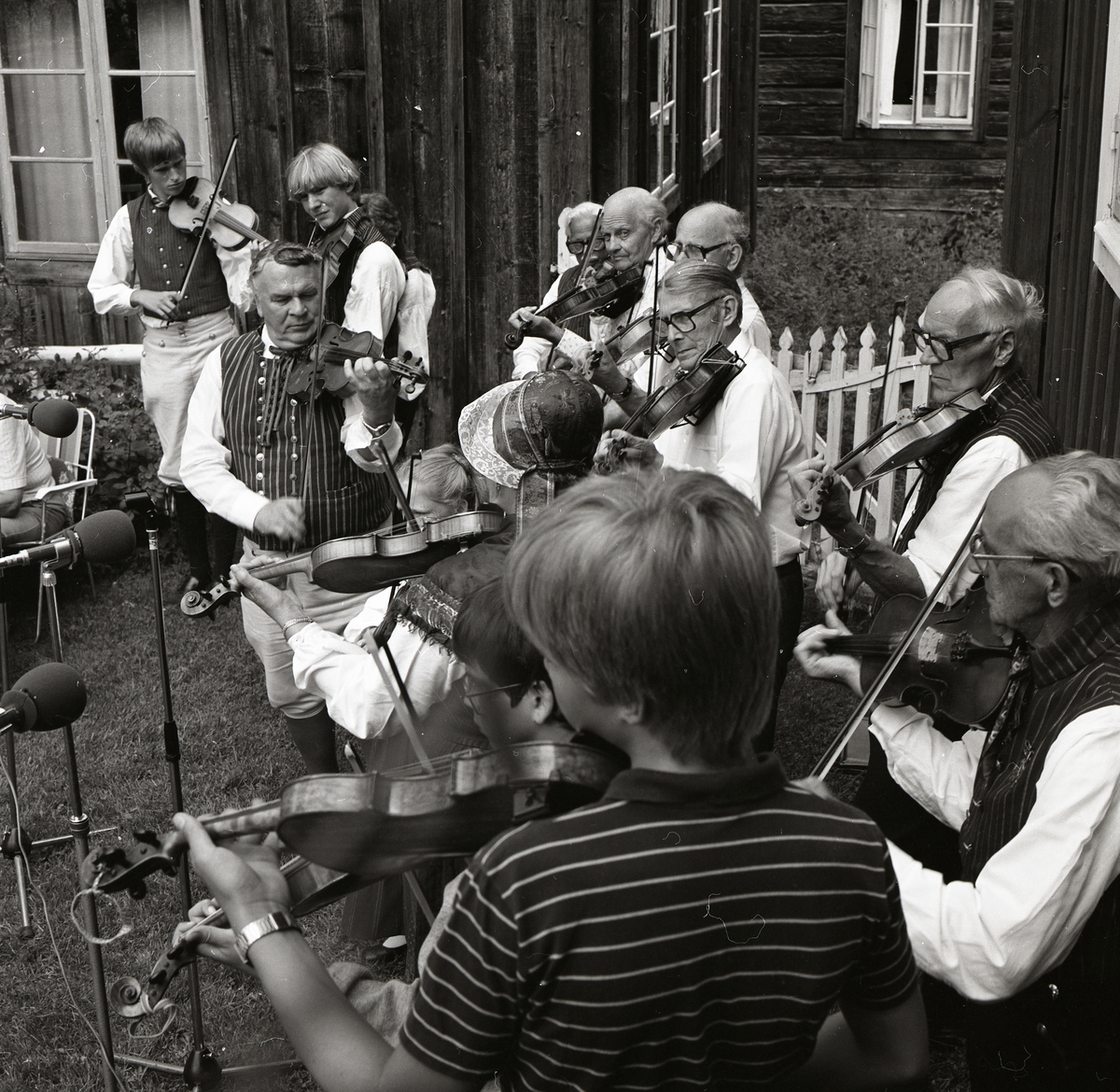 En grupp fiolspelare uppträder vid Rengsjöfesten, 18 juli 1982. Spelarna är iförda folkdräkter.