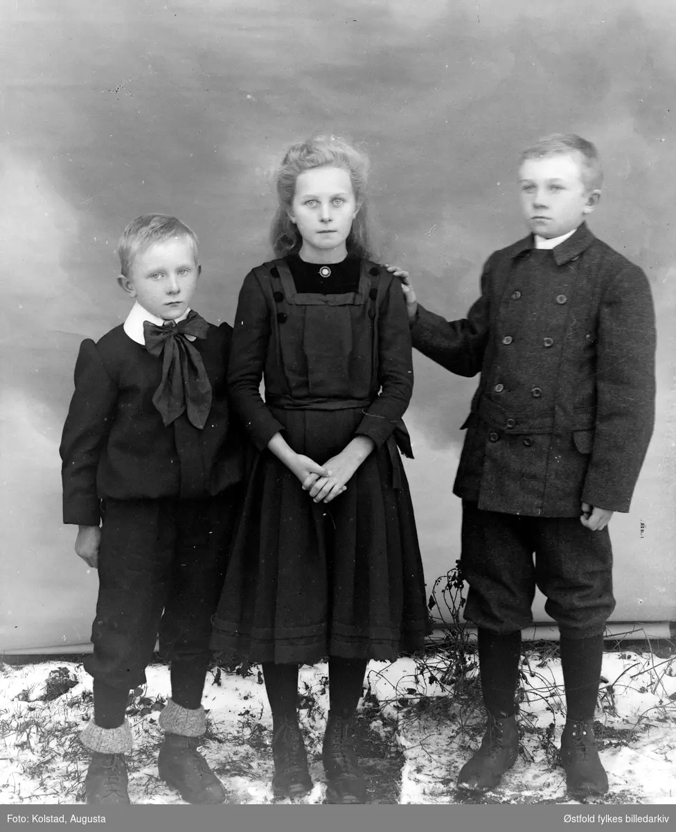 Gruppeportrett av tre  ukjente barn, antakelig søsken.