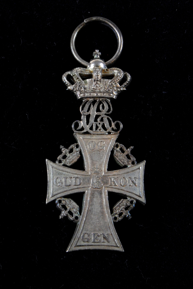 Ett danskt hederstecken i skepnaden av ett silverkors, Dannebrogmændenes Hæderstegn. Korset är gjutet i silver och är dekorerat med fem kungakronor (varav fyra är små). Den största kungakronan, som sitter överst på korset, är placerad ovanför de sammanflätade initialerna som tillhör kung Christian IX. Det ska finnas ett vitt ordensband med röda ränder till hederstecknet men det saknas.