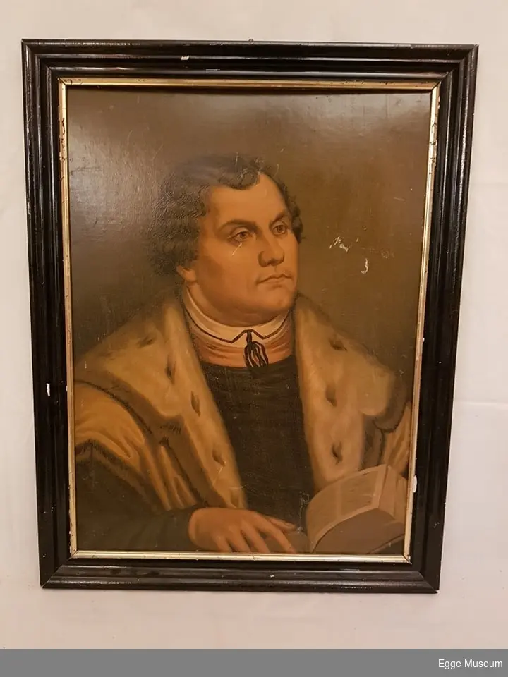 Bildet viser Martin Luther som holder en åpen bok.