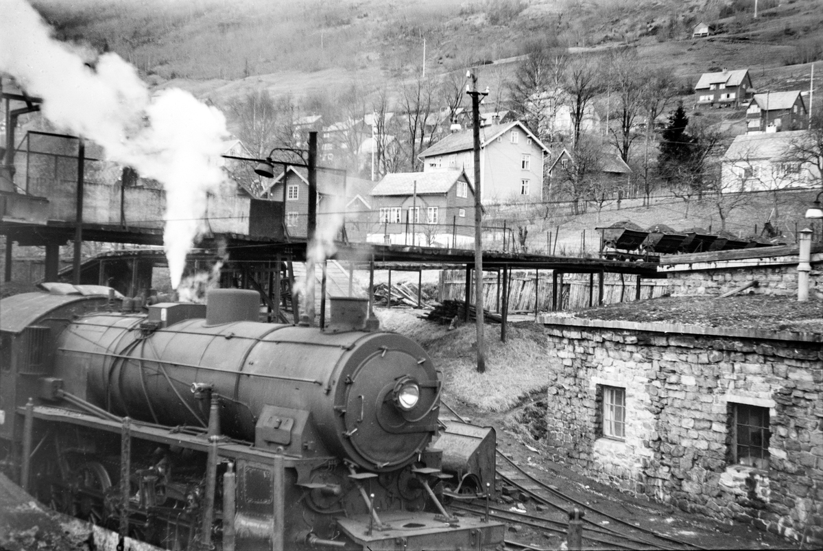 Damplokomotiv type 31b nr. 419 ved lokomotivstallen på Voss stasjon. I bakgrunnen vagger som ble benyttet til transport av kull til damplokomotivene.