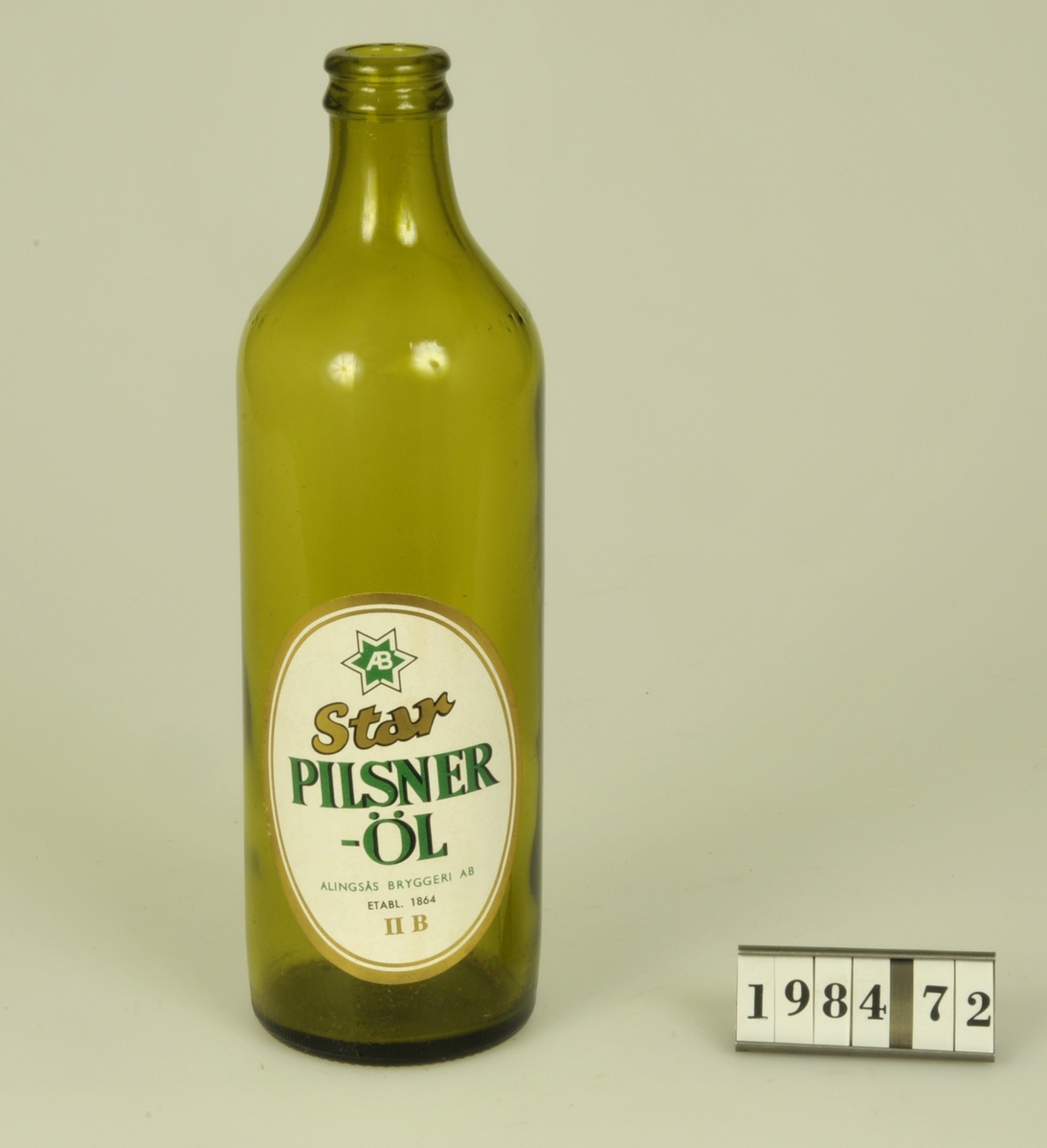 Butelj av grönfärgat glas, Etikett: "Star Pilsner-Öl Alingsås
Bryggeri AB Etabl. 1864 11B".

Märkt i botten: "PLM 6-6 S08".
