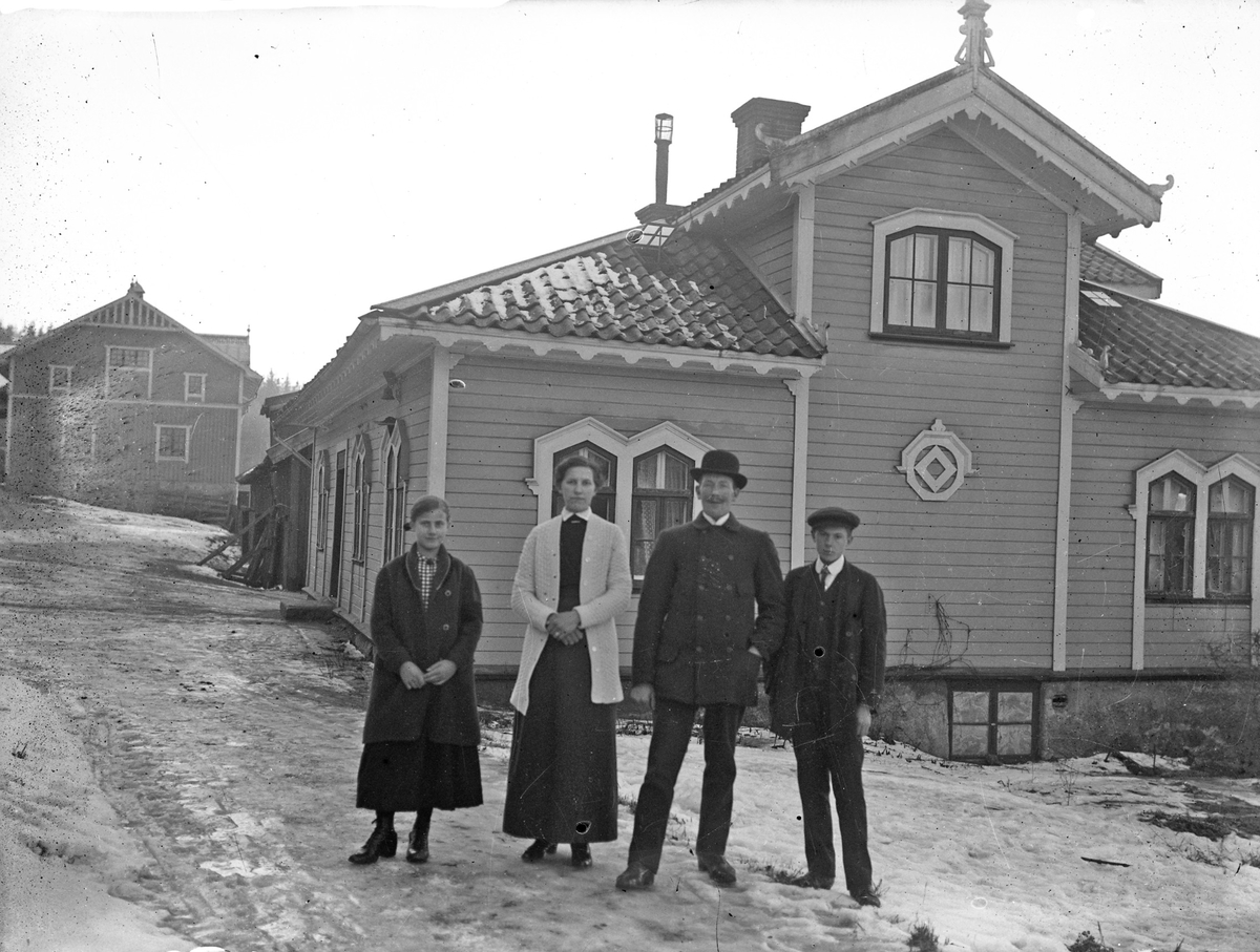 Delar av familjen Åsén, dotter, mor och far och en av sönerna. Familjen bodde på Österbodarne, fadern var lantarbetare/statare där. De står framför en av gårdens byggnader. Möjligen var det där de bodde.