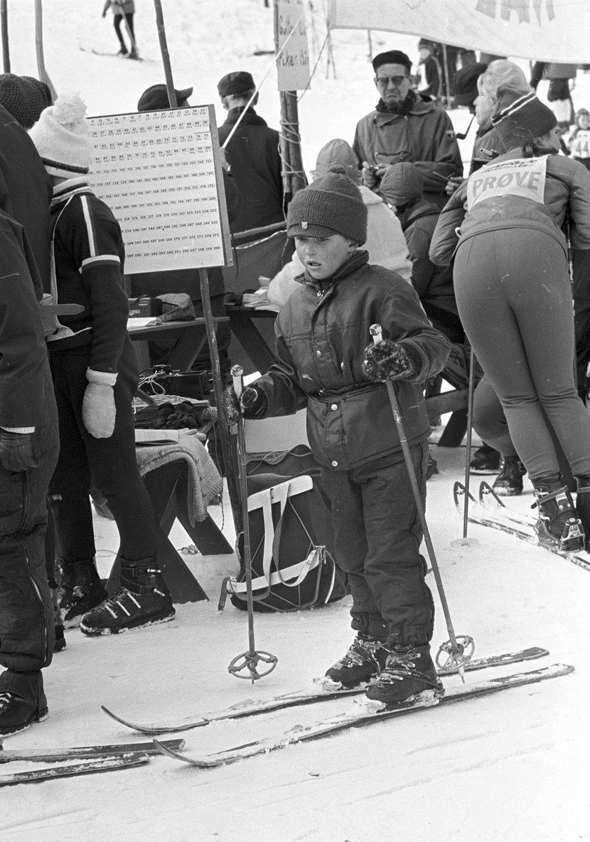 En gutt med ski på beina i står målområdet, "Aprilspøken" slalåmrenn i Tryvannskleiva. Fotografert 23. mars 1969.