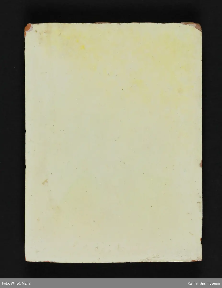 KLM 17887. Kakelugn. Av röd lerskärv och gulglaserad. Flat ugn med hylla. Krönlist och fris med palmettorn i relief. Skänkfris med bladranka.

Förteckning över samtliga kakel, med mått inom parentes, gjord i samband med inventering 1964:  
:1.  1 st. fasadkakel         (27x10,5 cm)
     1 st.  -"-                    (27,5x10,5 cm)
     1 st.  -"-                    (18,5x21 cm)
     10 st.  -"-                  (26,5x21 cm)
     13 st.  -"-                  (28x21 cm)
     2 st.  -"-                    (28x20 cm)
     2 st.  -"-                    (30,5x21,5 cm)
:2. 1 st.  -"-                    (28x22 cm) rutmönstrad dekor, jämför KLM 38937.
:3. 3 st.  -"-   sockel        (30,5x23,5 cm) brunglaserad
     2 st.  -"-  sockel         (30x18 cm)
:4. 4 st. listkakel, fotlist    (14x20,5 cm)
:5. 8 st. hörnkakel           (26,5x23 cm) rätvinkligt hörn
:6. 5 st. hörnkakel           (28x23 cm) rundade hörn
:7. 2 st. krönkakel           (10,5x21,5 cm)
:8. 9 st. kakelfragment varav ett med dekor i svart, grönt och rött i form av en stiliserad bladslinga.