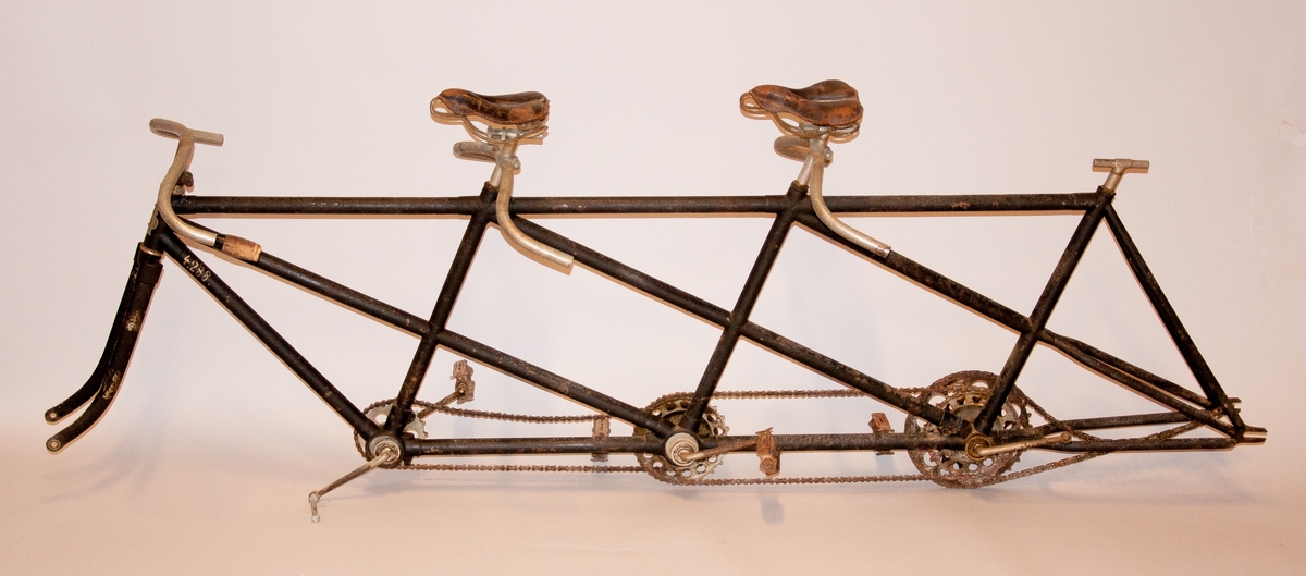 Tresitsig cykel. Lösa delar: tre styren, tre sadlar och tre par pedaler. Flera delar fattas. Axelavstånd: 2280 mm. Ramens höjd: 770 mm.