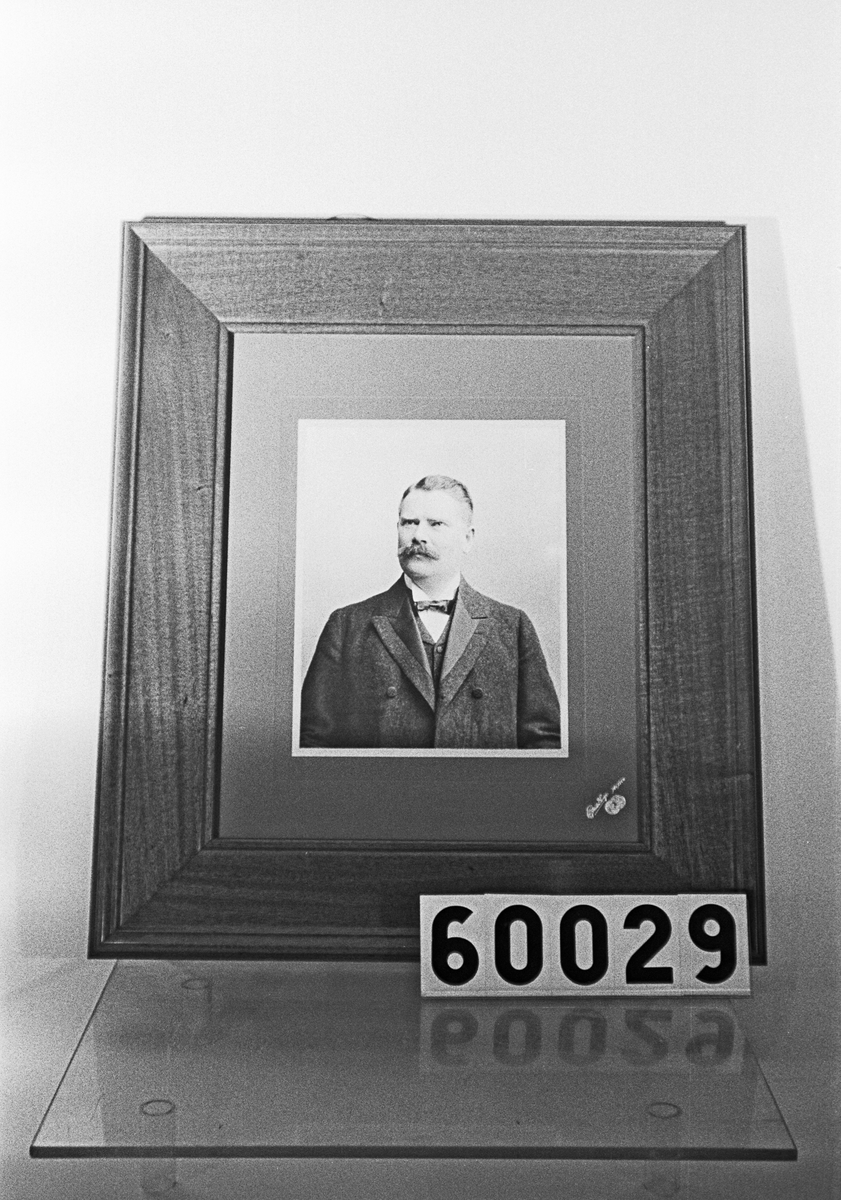 Inramat fotografi av direktör Axel Boström, i mahognyram med glas.