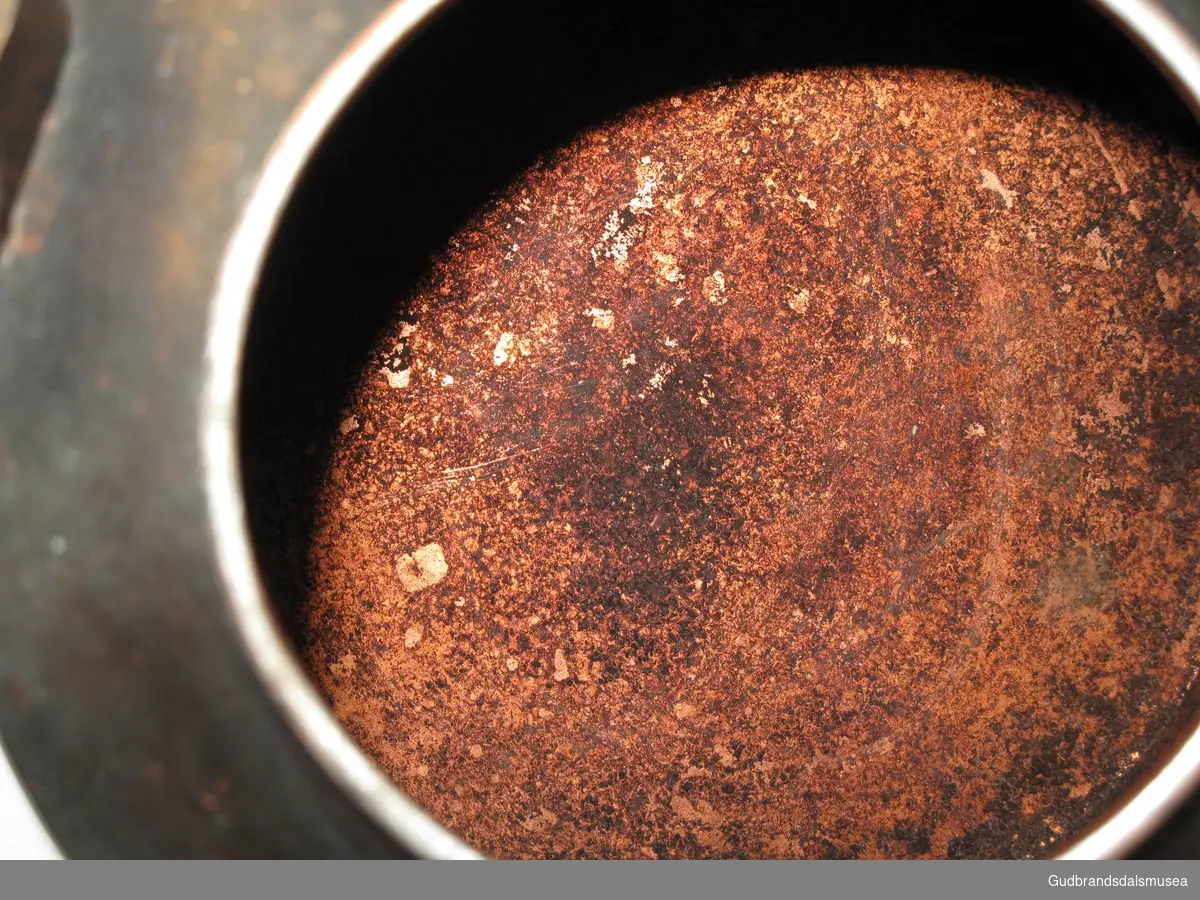 Liten kaffekjele i kobber. Tut og lokk. Bevegelig, nittet tverrhank i jern. Lokkgrepet mangler. Svartsotet bunn og korpus.