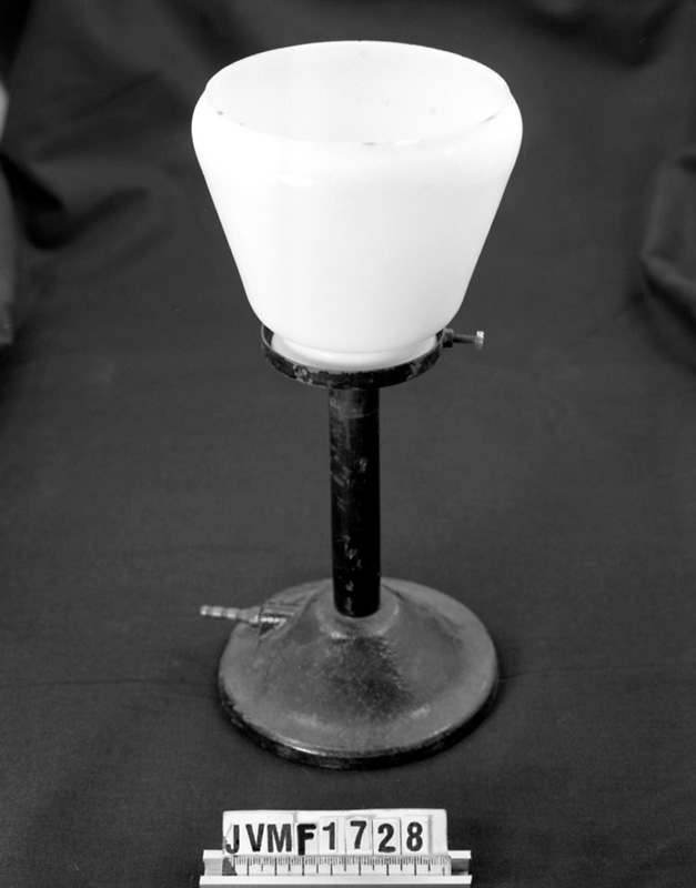 Karbidlampa av svart gjutjärn med glaskupa.