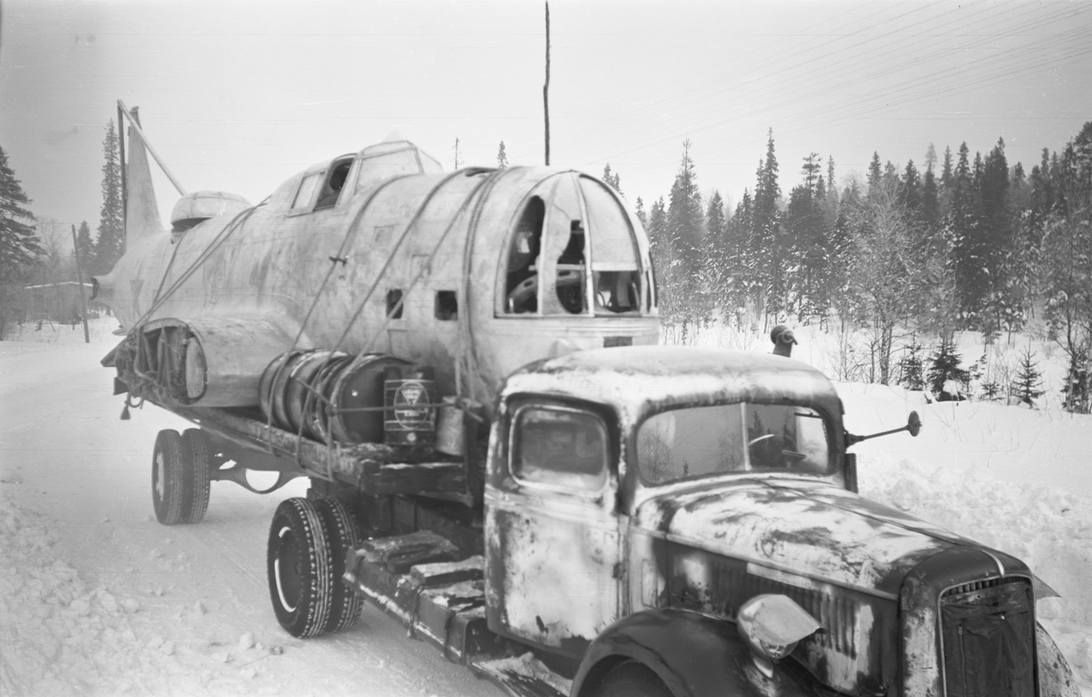 Transport av nedskjutet sovjetiskt flygplan DB-3 vid Svenska frivilligkåren i Finland, F 19. Flygplanet lastat på vagn efter lastbil.