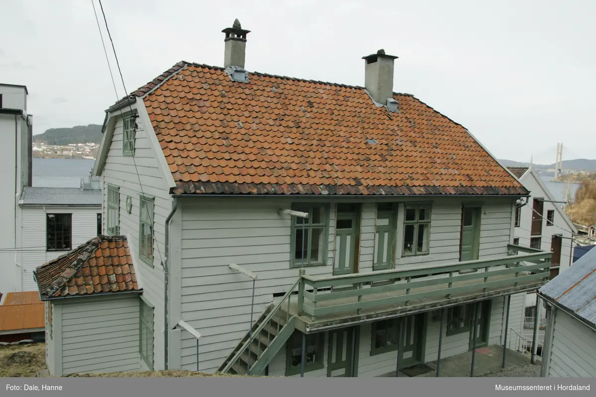 Den første arbeidarbustaden til Salhus Tricotagefabrik (1859-1989), bygd året etter fabrikken. Opphavleg inndelt i seks leilegheiter og sovesalar.