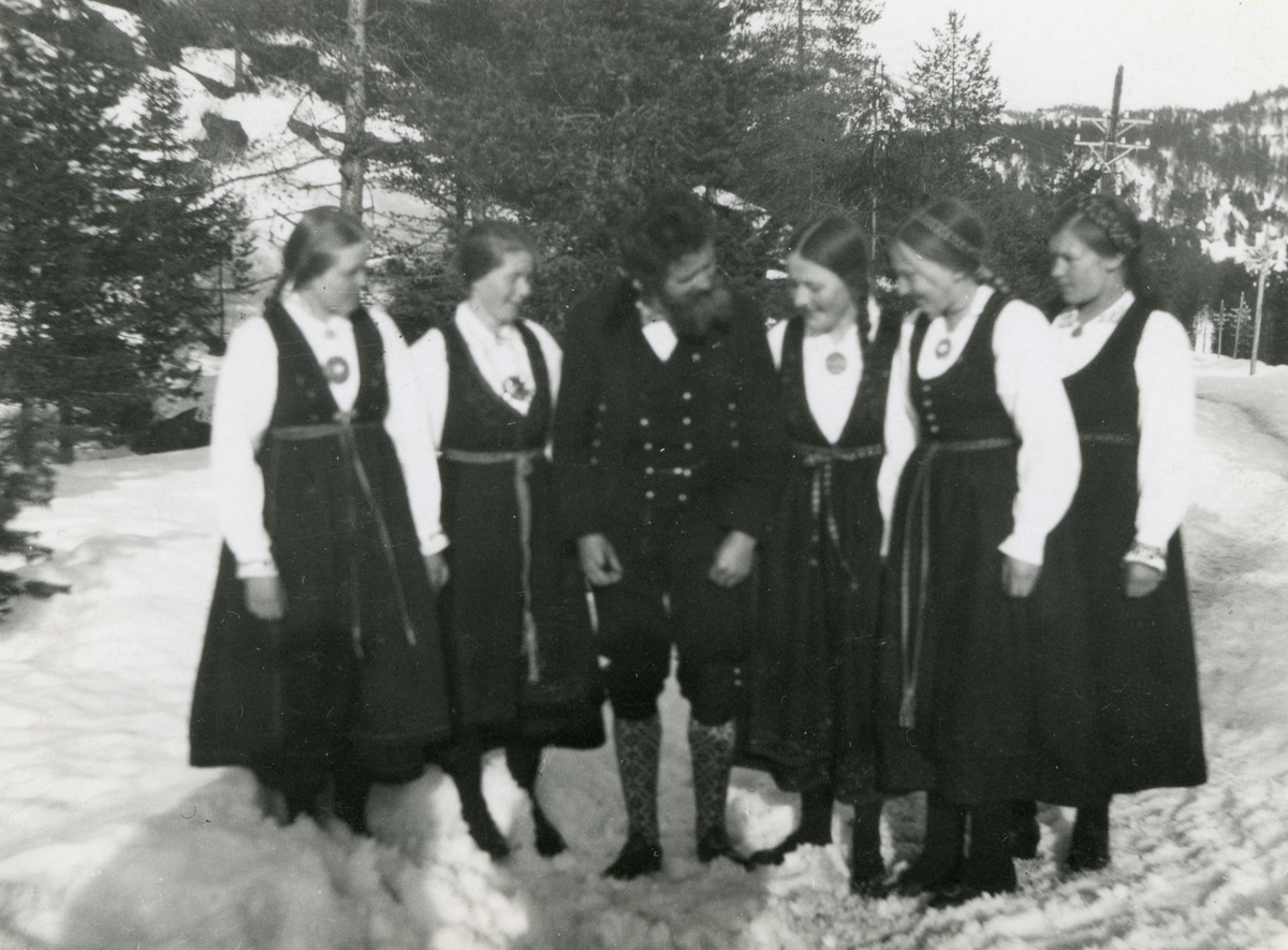 Portrett av Ingvald Skjeldrup sammen med fem kvinner i bunad.