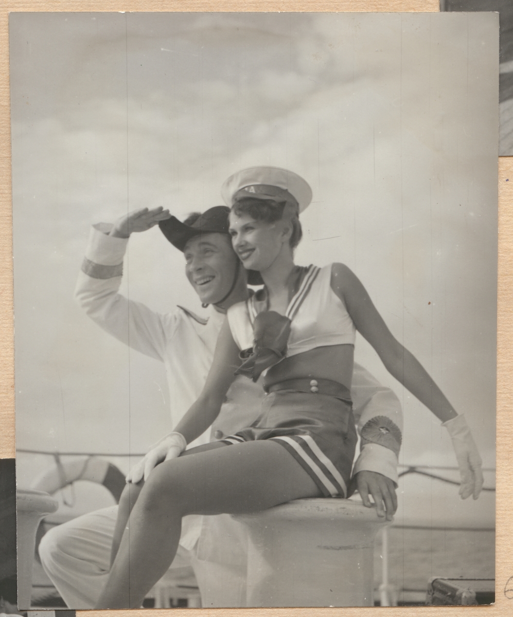 Här syns en lycklig leende skådespelare i amiralskostym bredvid en balettflicka i sjömanskostym.