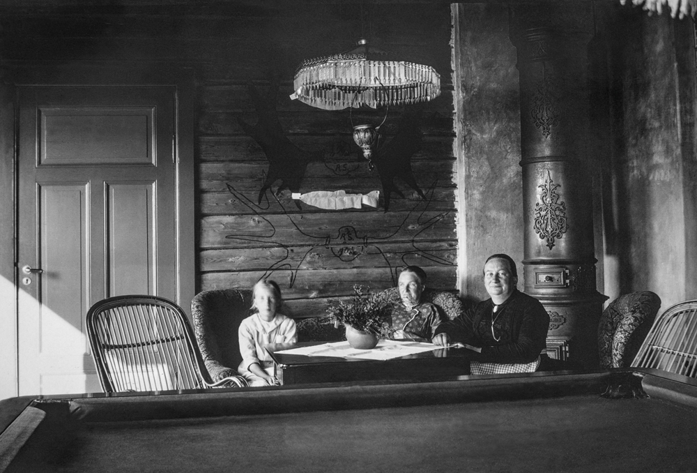 Svenning House i Svenningdalen. Interiør, to kvinner og en jente ved bord.